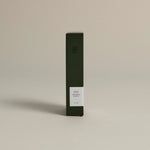 Minimalist dark green box labeled ‘001 Smoking Jacket – Focus’ by FORGRAVE, standing upright on a beige background.