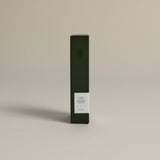 Minimalist dark green box labeled ‘001 Smoking Jacket – Focus’ by FORGRAVE, standing upright on a beige background.