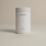 White tea canister labeled ‘001 Smoking Jacket Green Blend’ on a beige background.