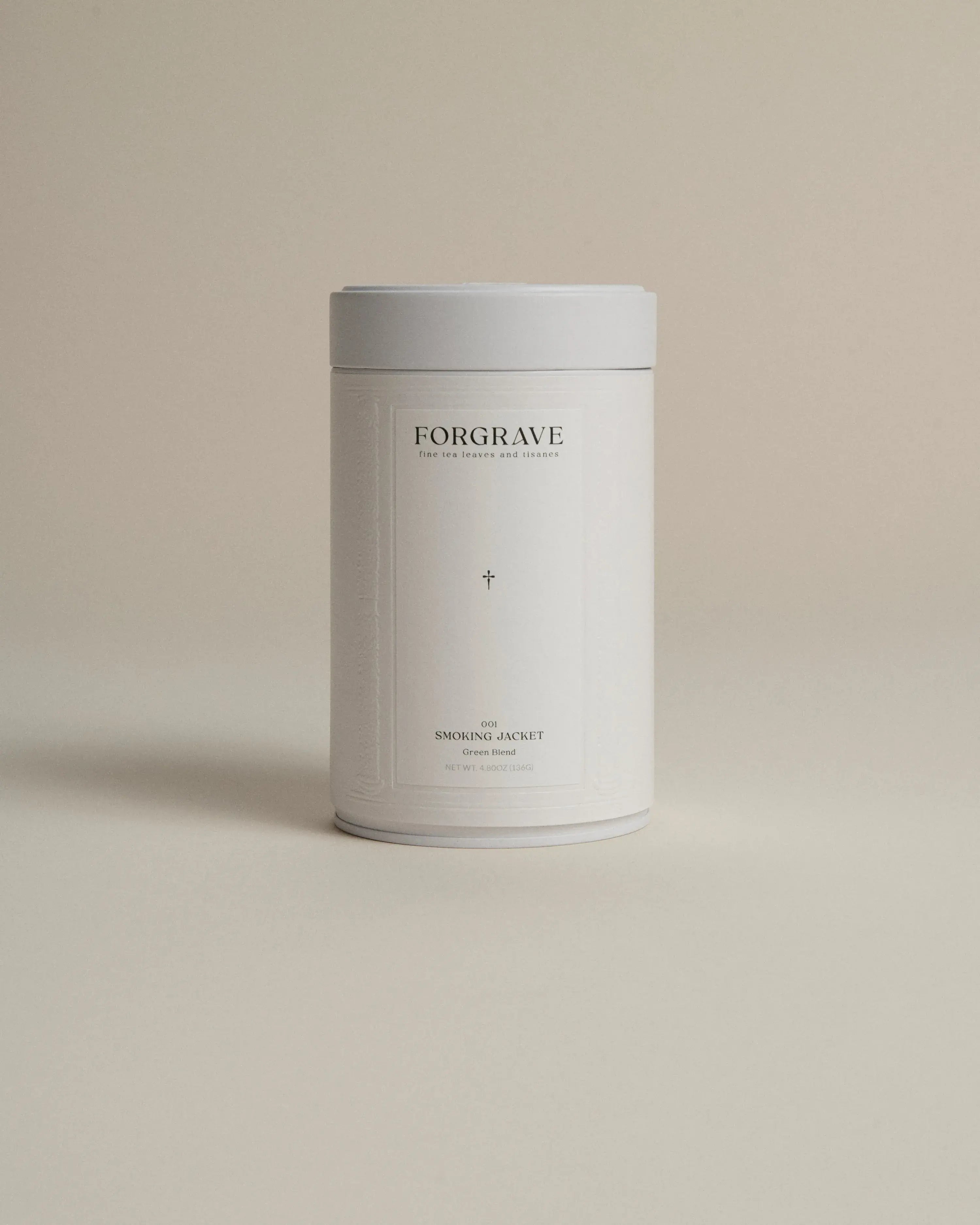 White tea canister labeled ‘001 Smoking Jacket Green Blend’ on a beige background.