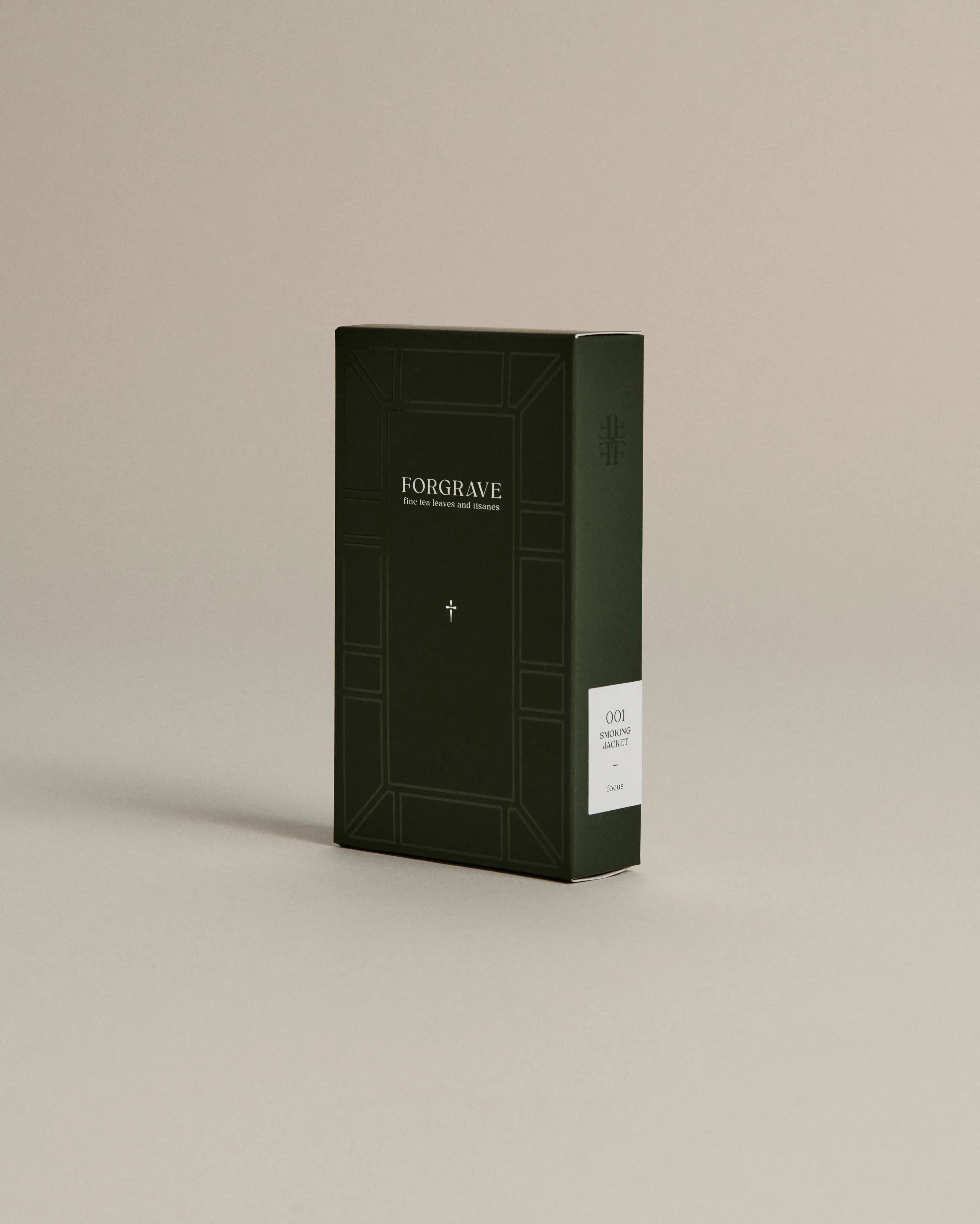 Dark green box of ‘FORGRAVE Fine Tea Leaves and Tisanes, 001 Smoking Jacket’ with minimalist design on a beige background.