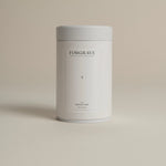 White tea canister labeled ‘002 Bright Side Black Blend’ on a beige background.