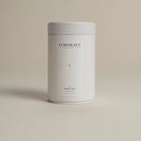 White tea canister labeled ‘002 Bright Side Black Blend’ on a beige background.
