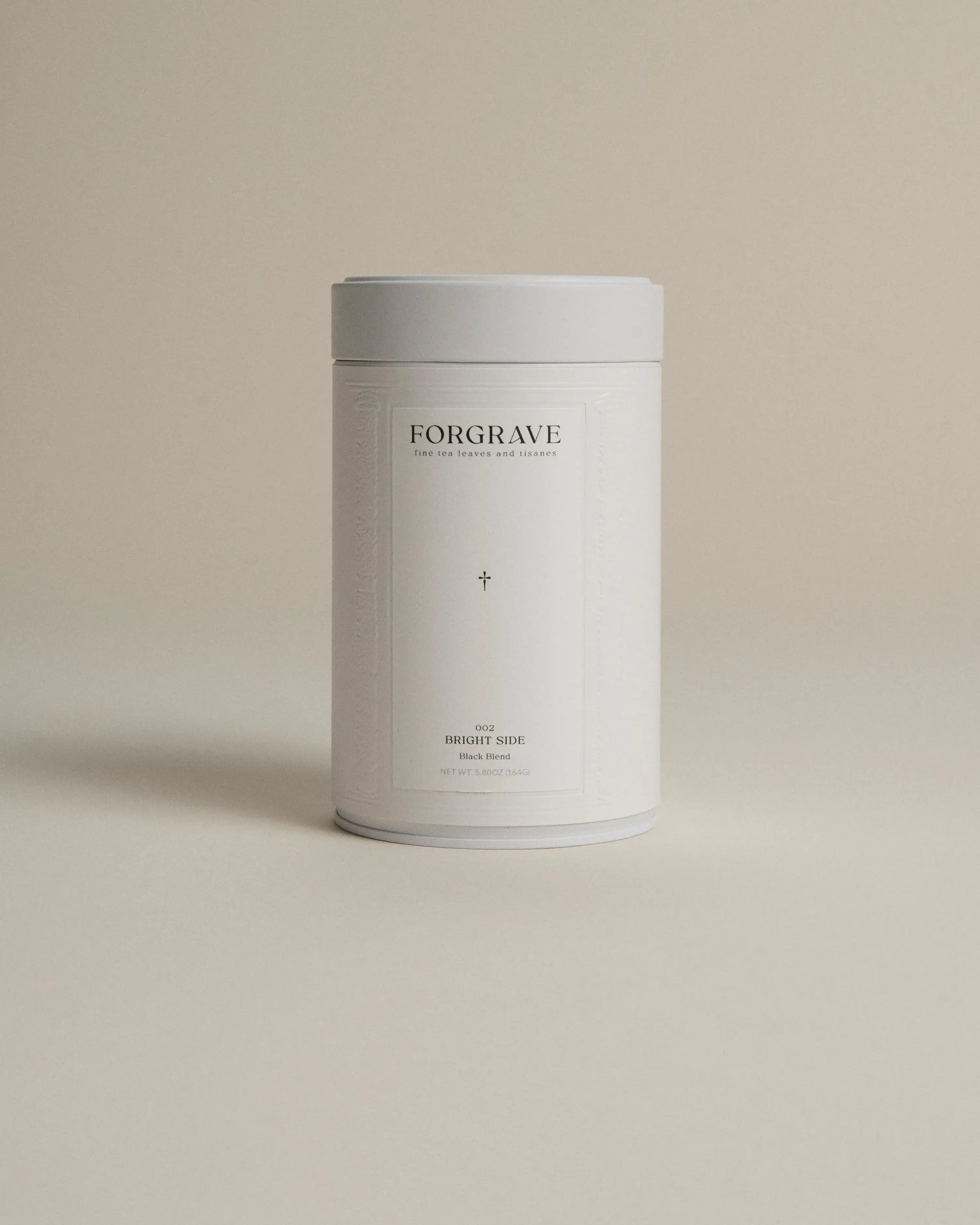 White tea canister labeled ‘002 Bright Side Black Blend’ on a beige background.