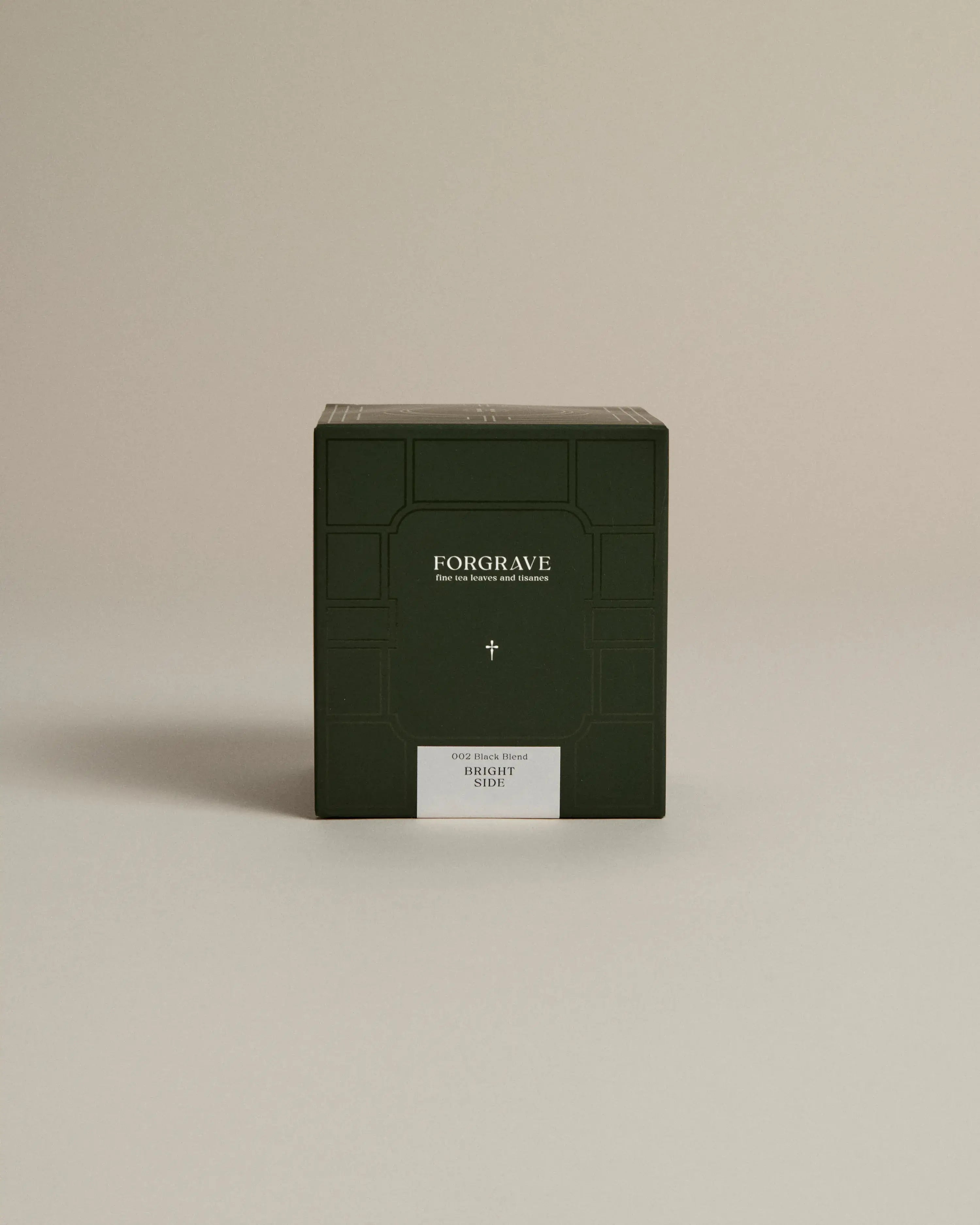 Dark green box labeled ‘FORGRAVE Fine Tea Leaves and Tisanes, 002 Black Blend Bright Side on a beige background.