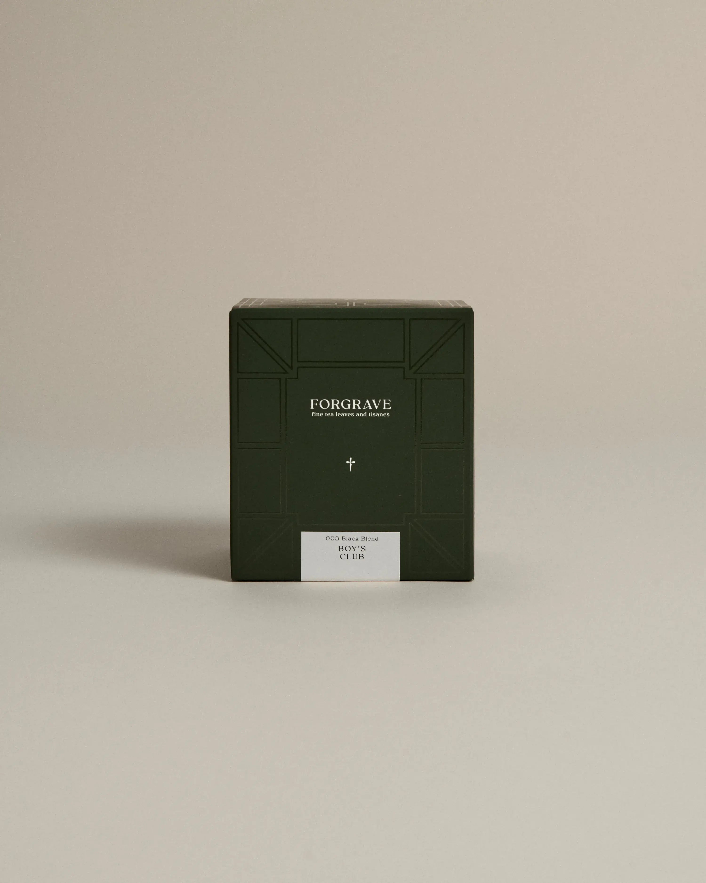 Dark green box labeled ‘FORGRAVE Fine Tea Leaves and Tisanes, 003 Black Blend Boy's Club on a beige background.