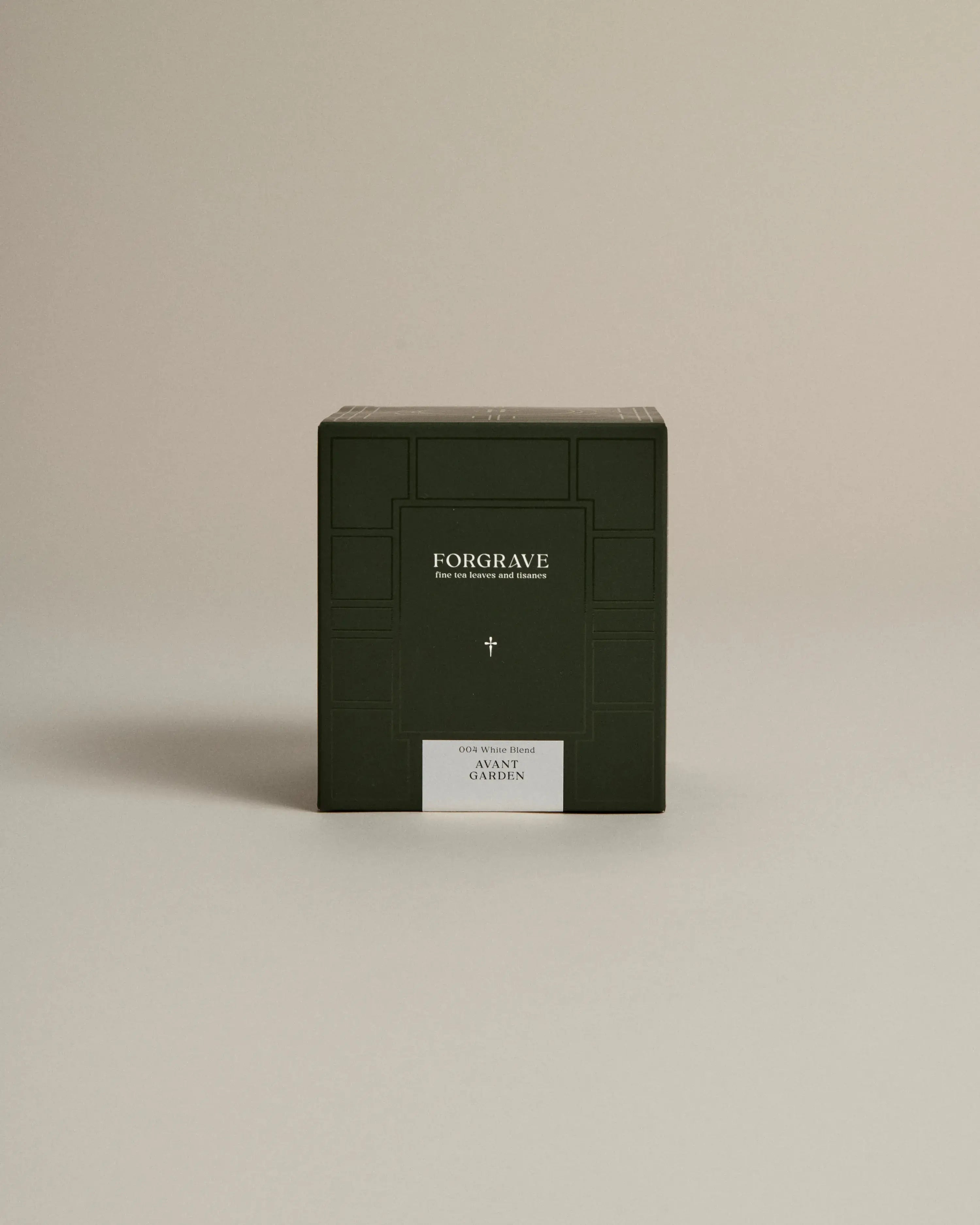 Dark green box labeled ‘FORGRAVE Fine Tea Leaves and Tisanes, 004 White Blend Avant Garden on a beige background.