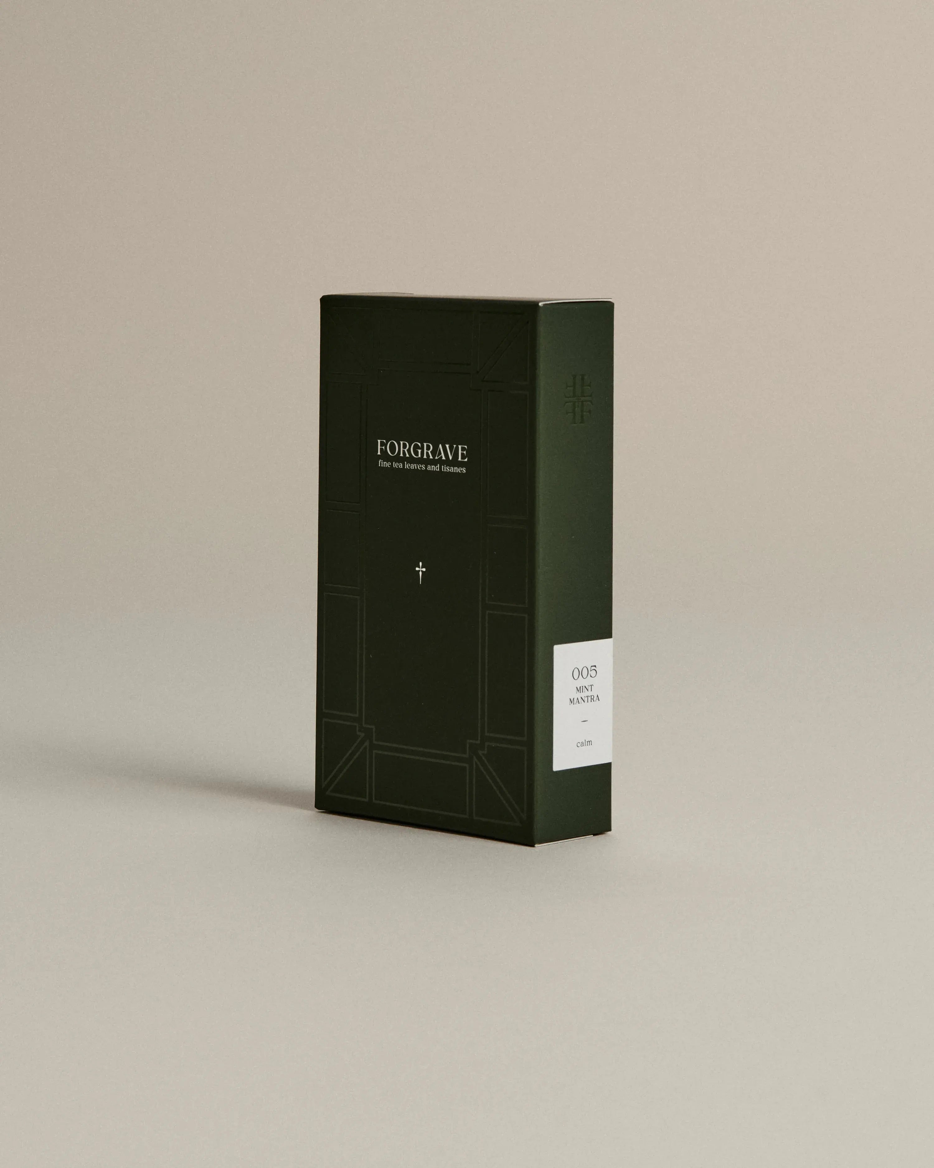 Dark green box of ‘FORGRAVE Fine Tea Leaves and Tisanes, 005 Mint Mantra’ with minimalist design on a beige background.