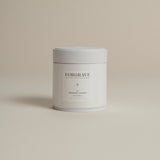 White tea canister labeled ‘001 Smoking Jacket Green Blend’ on a beige background.