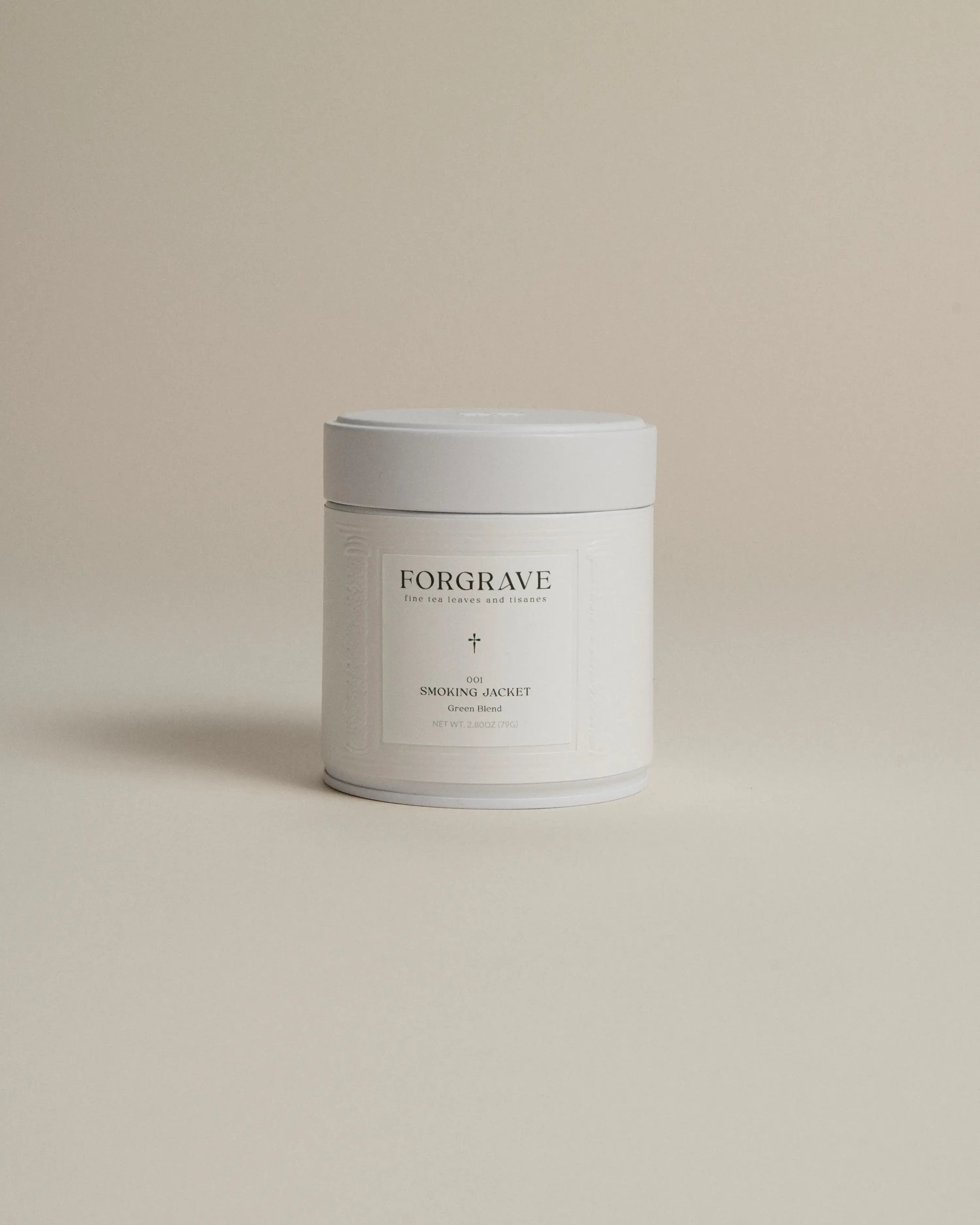 White tea canister labeled ‘001 Smoking Jacket Green Blend’ on a beige background.