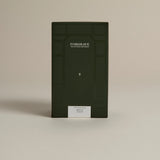 Dark green box labeled ‘FORGRAVE Fine Tea Leaves and Tisanes, 003 Black Blend Boy's Club on a beige background.