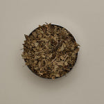Open Forgrave Augusta Medium Caddy viewed from above, filled with organic loose leaf tea — dried whole leaves and stems in a refillable tin